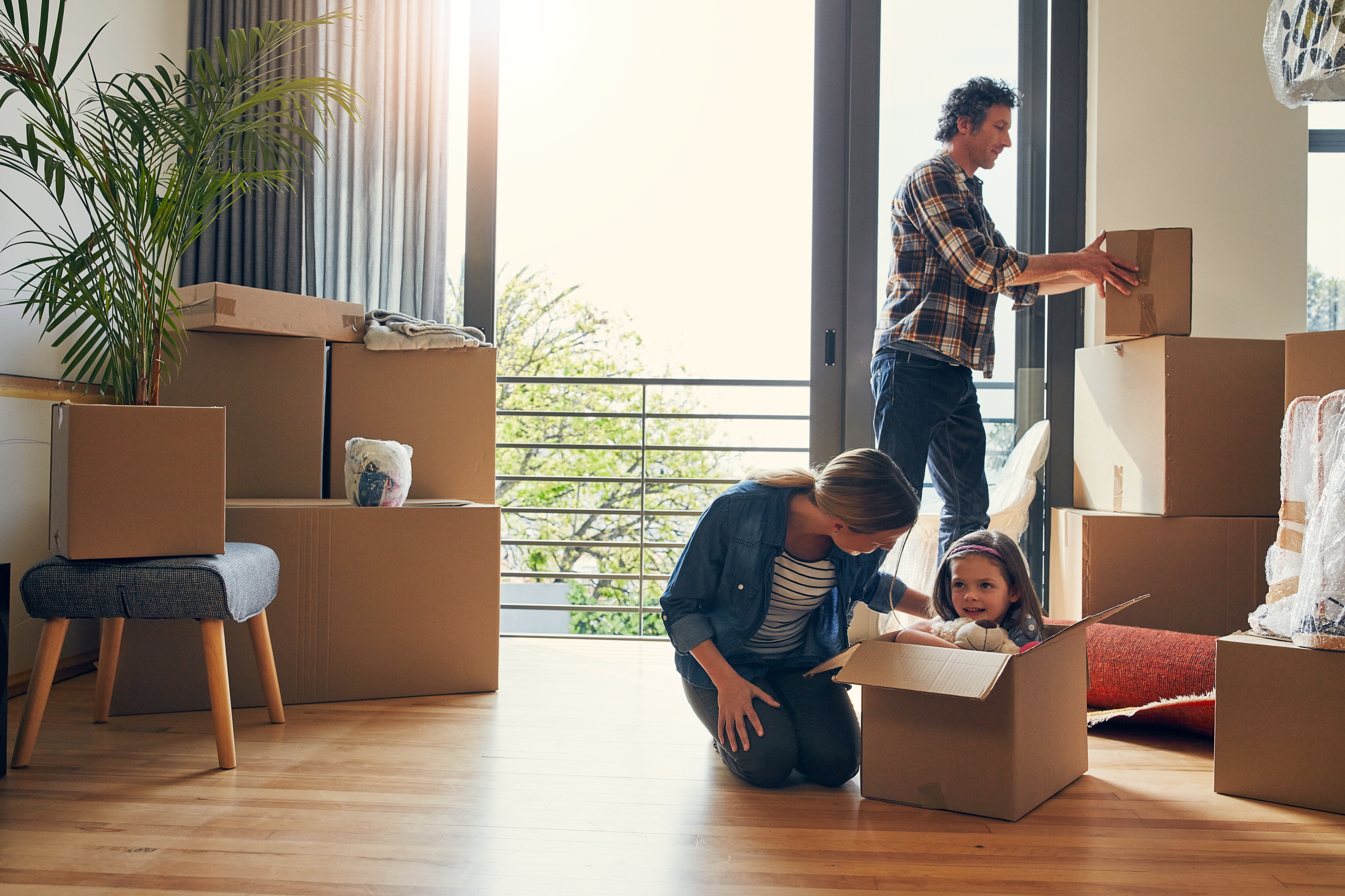 Photo of a family packing moving boxes. 